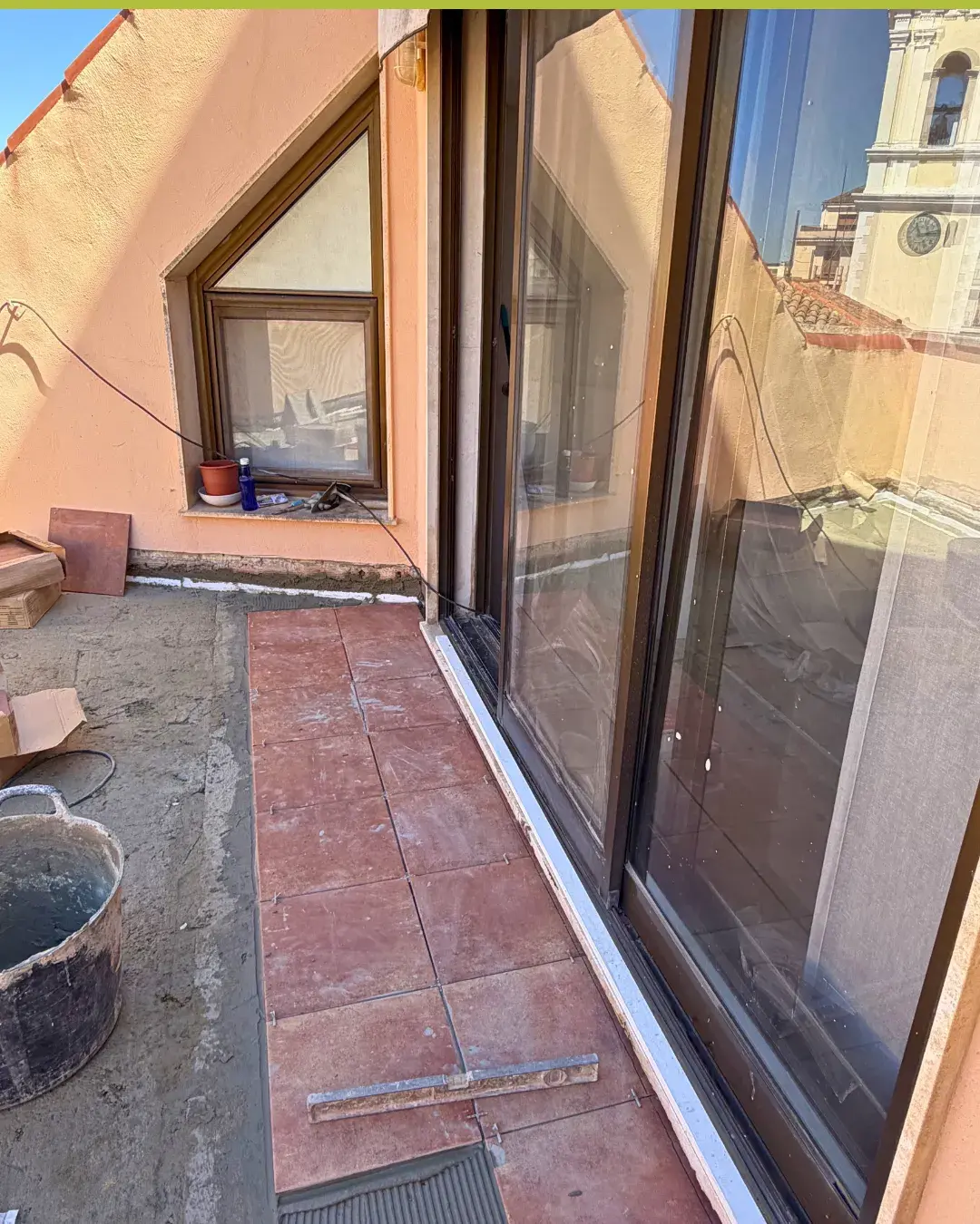 Detalle del inicio de colocación de la nueva baldosa junto a carpintería